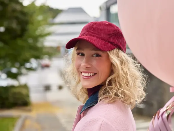dame i rosa antrekk og holder rosa ballong