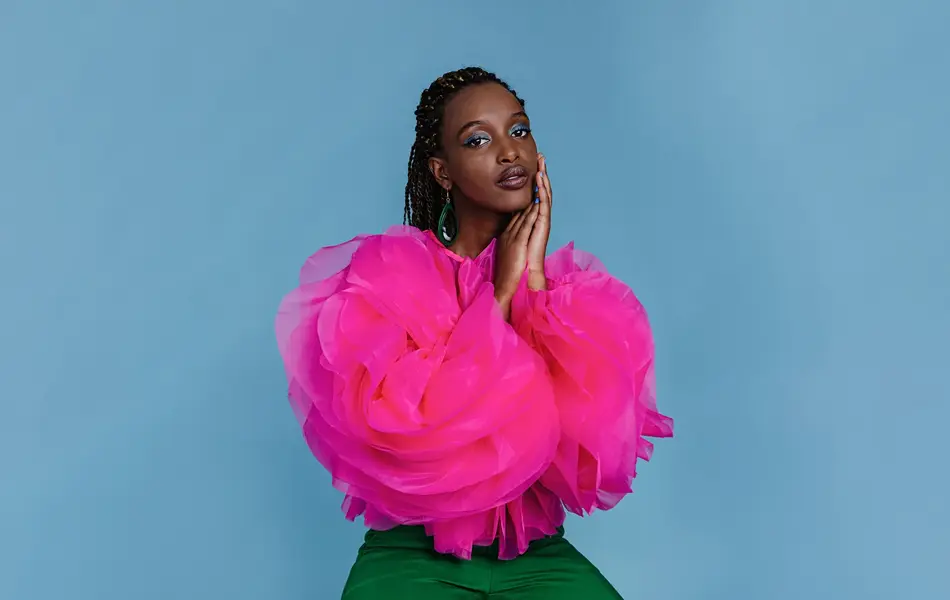 Kvinne i rosa topp foran blå bakgrunn