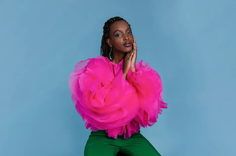 Kvinne i rosa topp foran blå bakgrunn