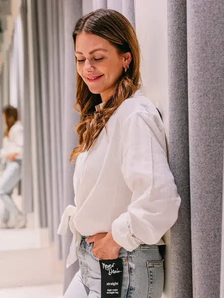 Dame som har på seg lyse jeans og hvit linskjorte