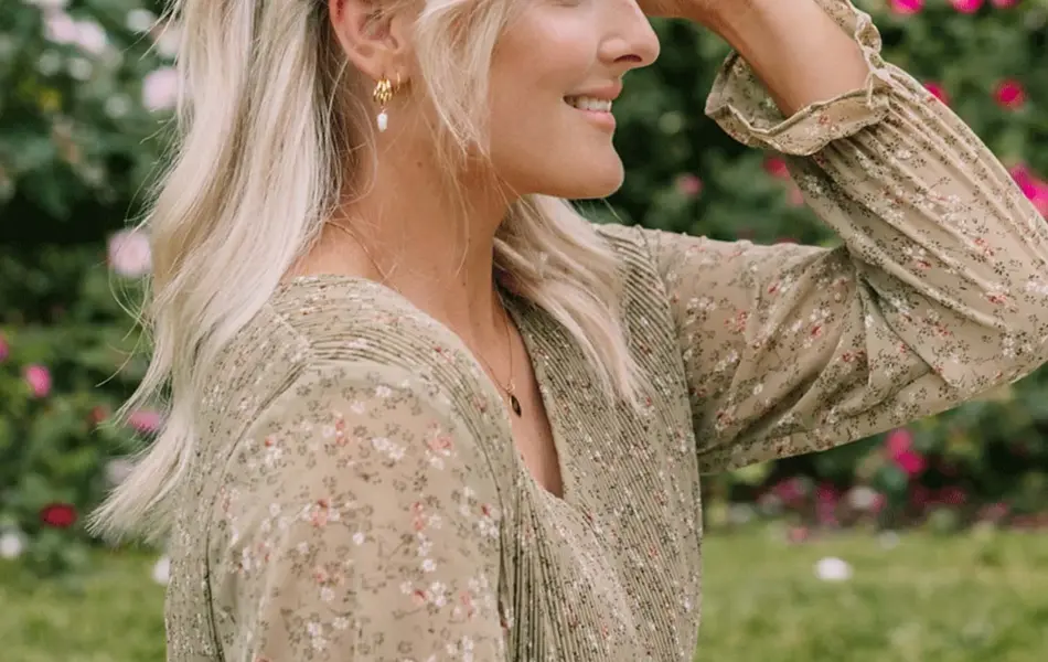 Dame som smiler og sitter på badestranden