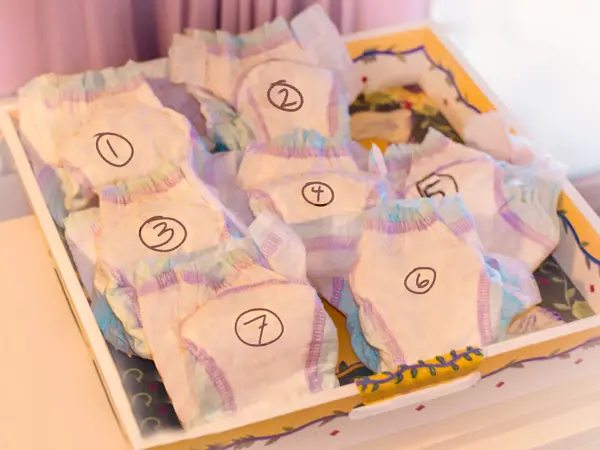 Numbered diapers in a box on a white table.