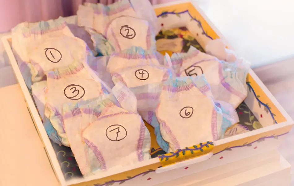 Numbered diapers in a box on a white table.