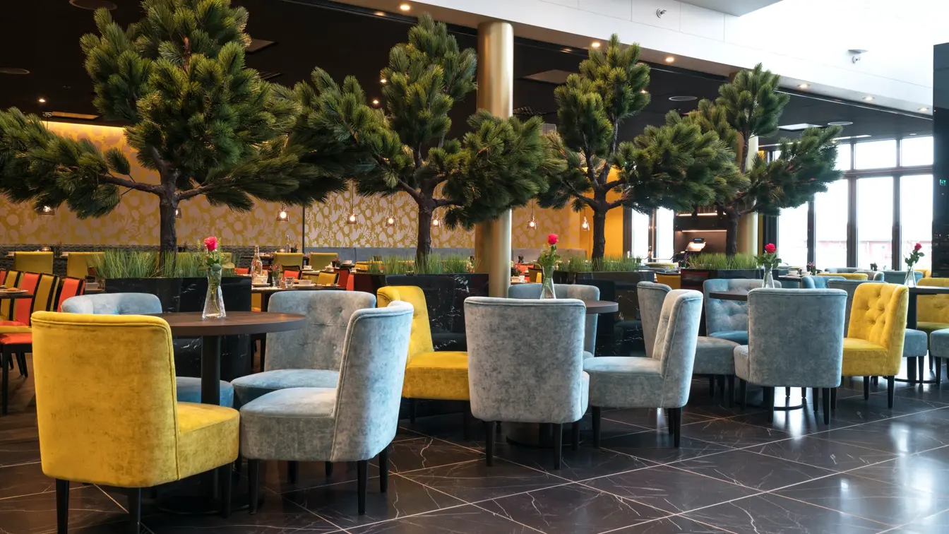 Lobby med planter og trær og sittegrupper på Thon Hotel Nordlys i Bodø sentrum