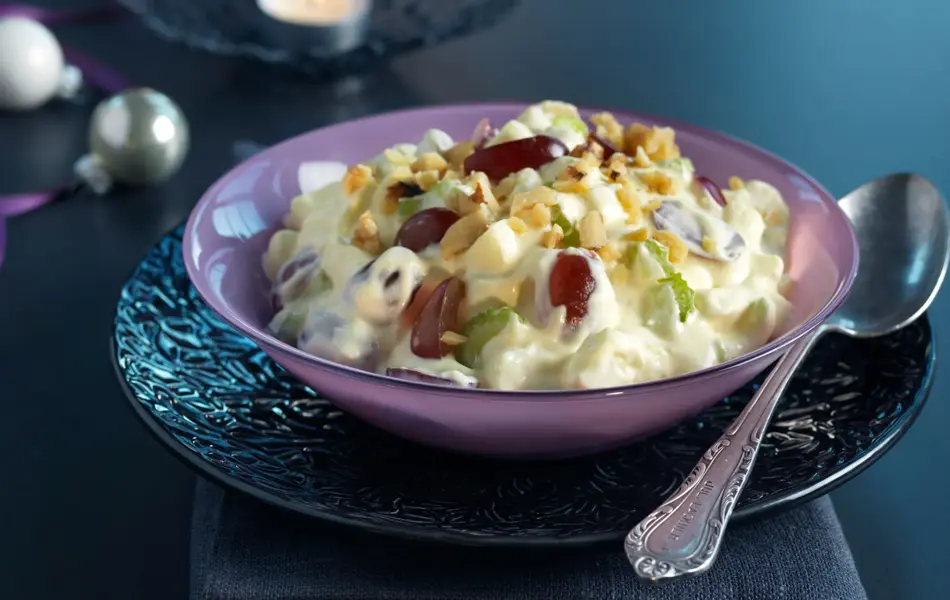 Waldorfsalat i en skål på et mørkt bord