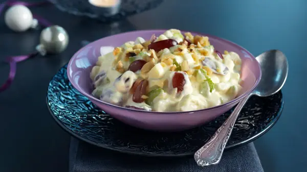 Waldorfsalat i en skål på et mørkt bord