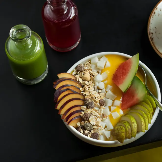 Smoothiebowl med fersk frukt og müsli, juice og te. 