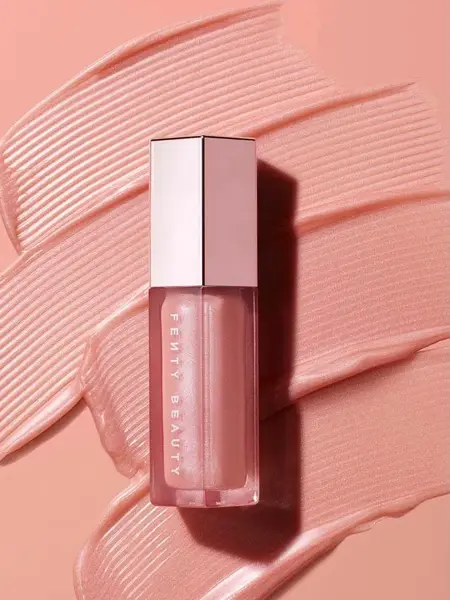 Rosa lipgloss med sølvkork som ligger på en rosa bakgrunn 