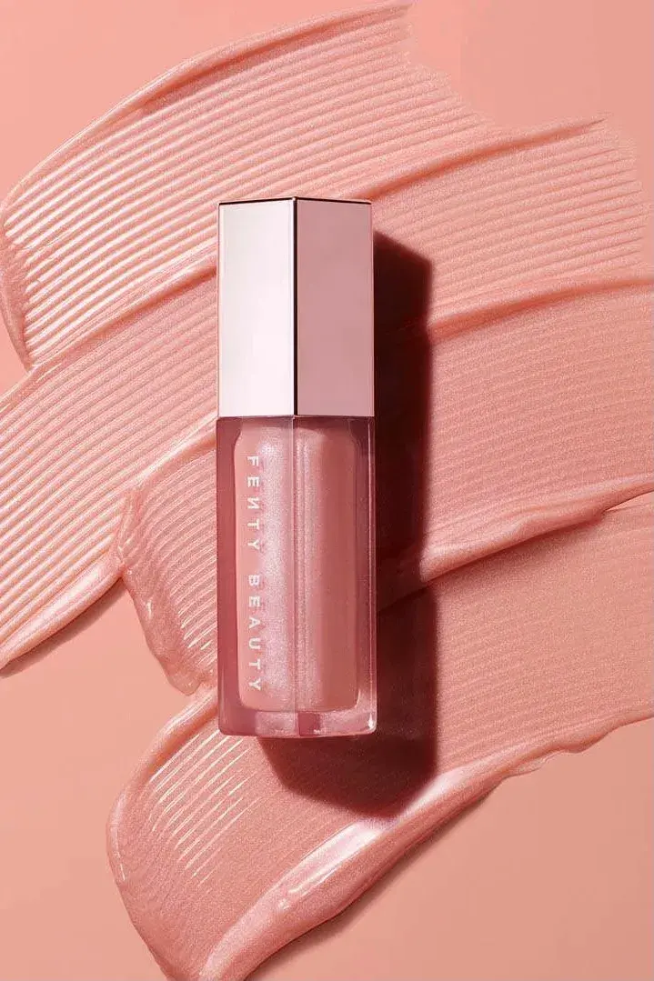 Rosa lipgloss med sølvkork som ligger på en rosa bakgrunn 