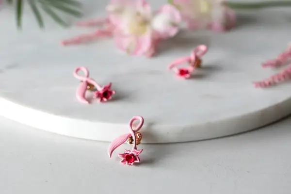 Rosa sløyfe pins ligger på et marmorbord