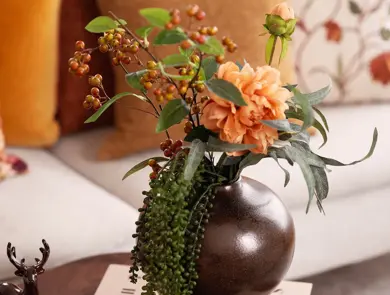 En vase med oransje stilkblomster.