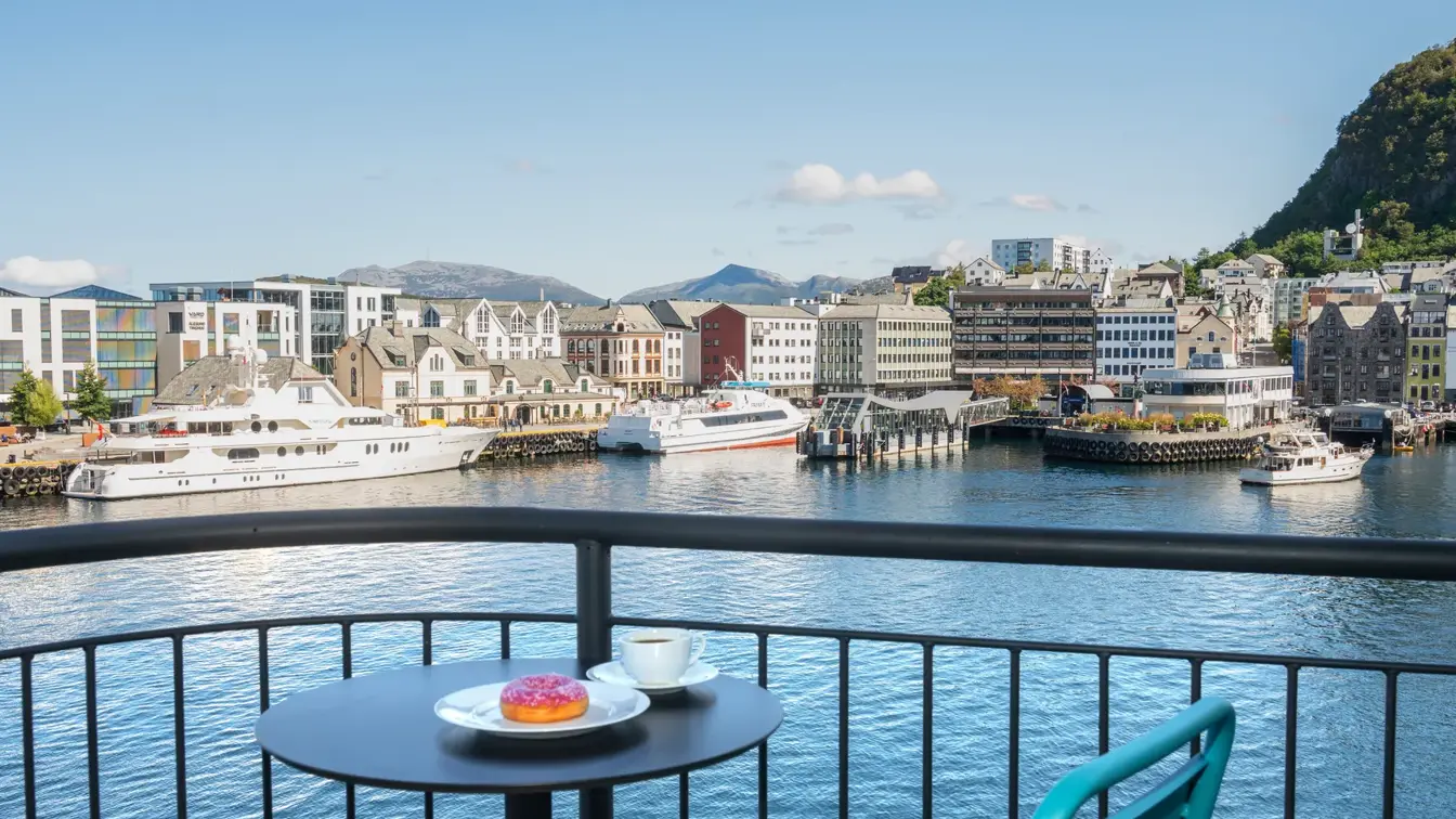 Balkong med utsikt over vannet og blå himmel, stoler, bord 