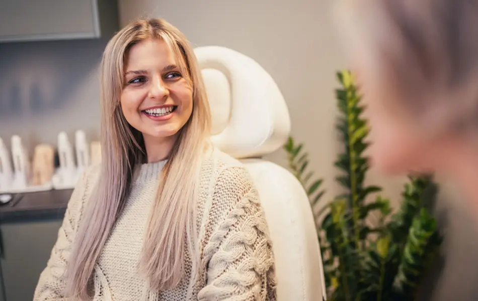 Smilende jente i behandlingsstol hudpleiesalongen Olio