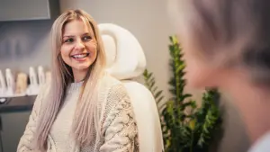 Smilende jente i behandlingsstol hudpleiesalongen Olio