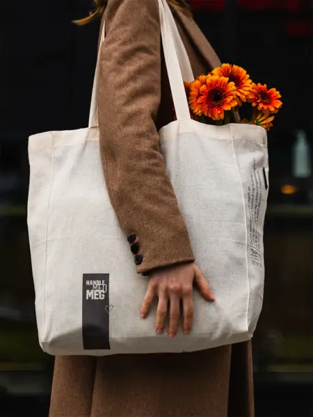 Dame som bærer et handlenett med blomster i