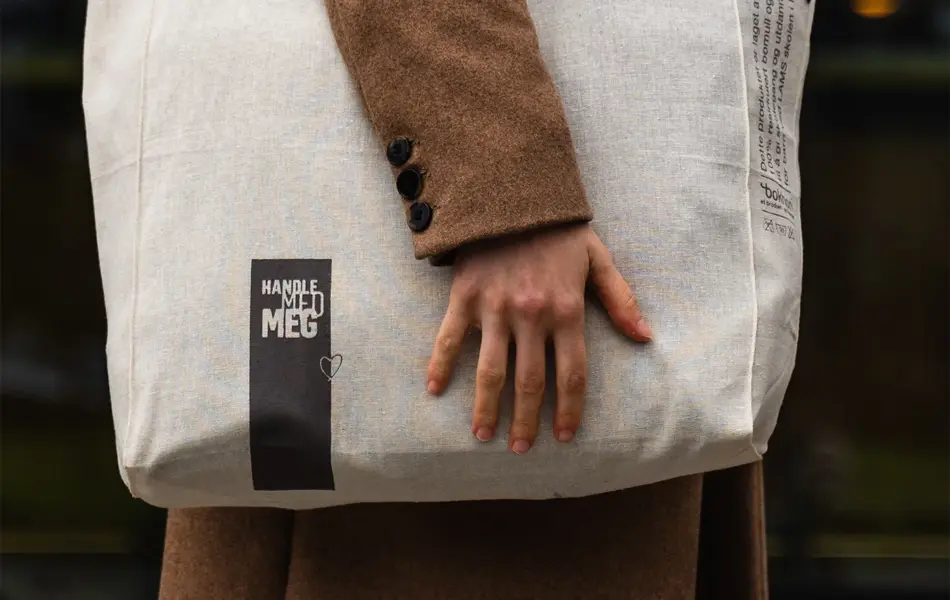 Dame som bærer et handlenett med blomster i