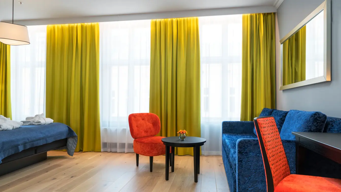 Dobbeltseng, skrivepult og sofa på buisness room på Thon Hotel Spectrum i Oslo sentrum