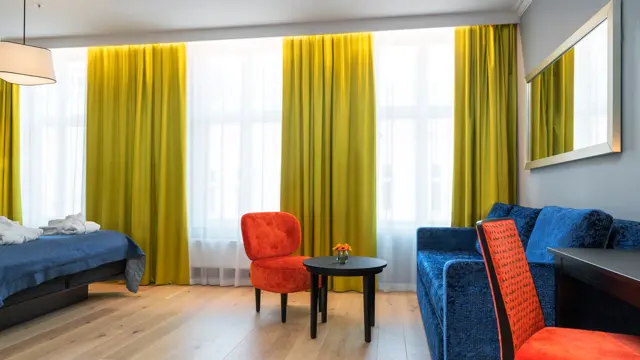 Dobbeltseng, skrivepult og sofa på buisness room på Thon Hotel Spectrum i Oslo sentrum