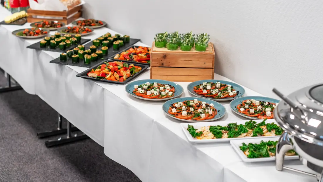 Selskapsbuffé med tapasmat på langbord dekket med hvit duk.