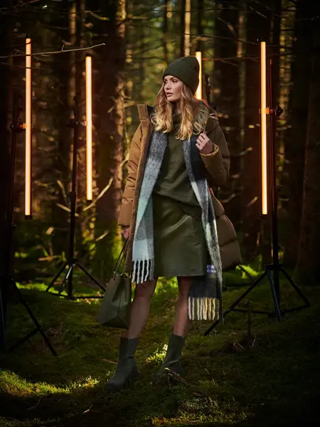 Dame i beige dunjakke i skogen