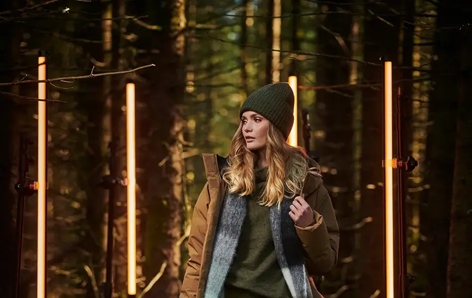 Dame i beige dunjakke i skogen