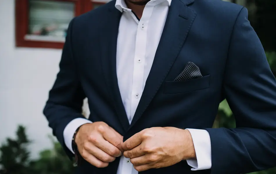 Nærbilde av mann med blå dressjakke, hvit skjorte og lilla lommetørkle