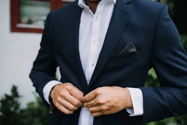 Nærbilde av mann med blå dressjakke, hvit skjorte og lilla lommetørkle