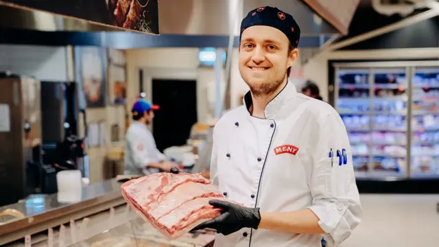 ansatt hos meny viser frem fin ribbe