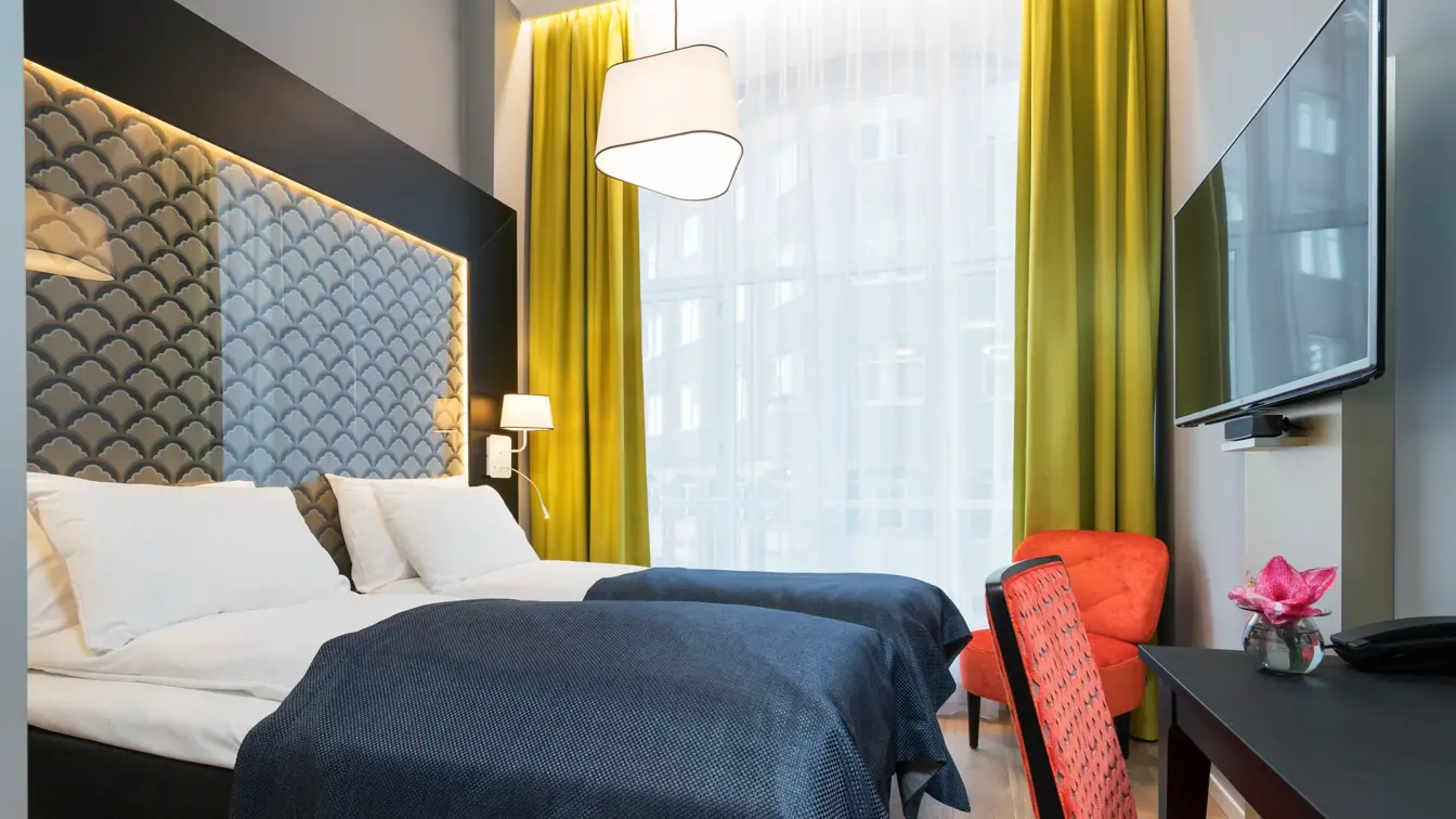 Dobbeltseng, skrivepult, stol, tv, og blomst  på Standard room twin på Thon Hotel Spectrum i Oslo sentrum