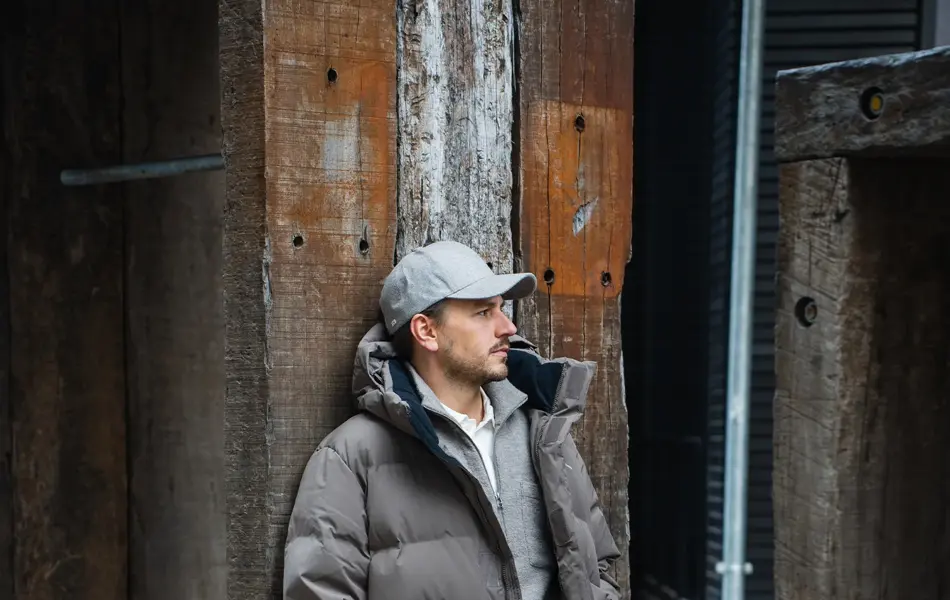 Mann som lener seg på en stolpe