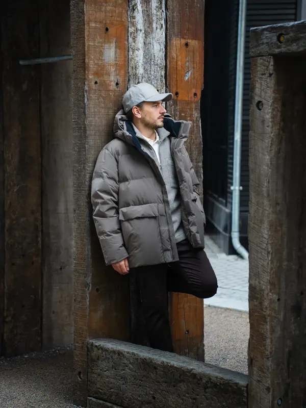 Mann som lener seg på en stolpe