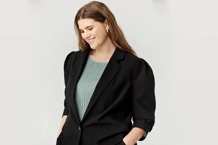 Dame har på seg blazer 