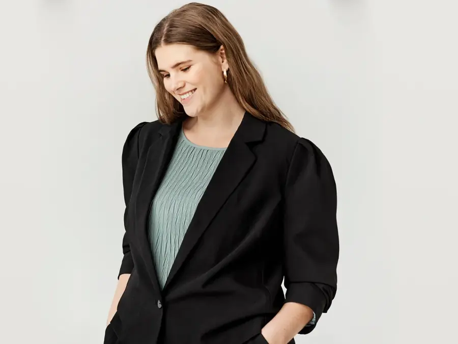 Dame har på seg blazer 