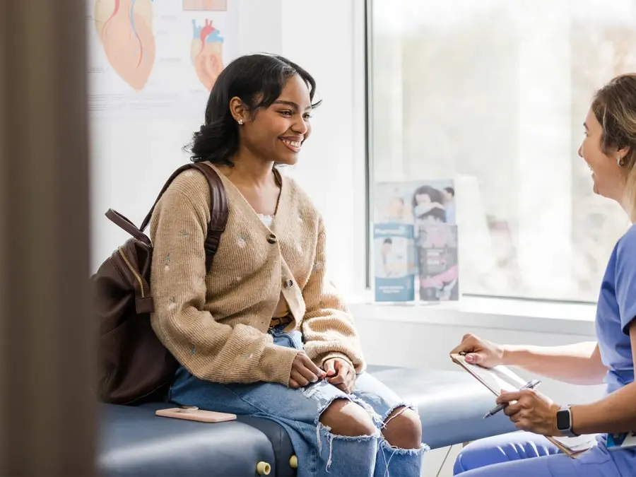 ung jente som snakker med helsesøster på kontoret hennes