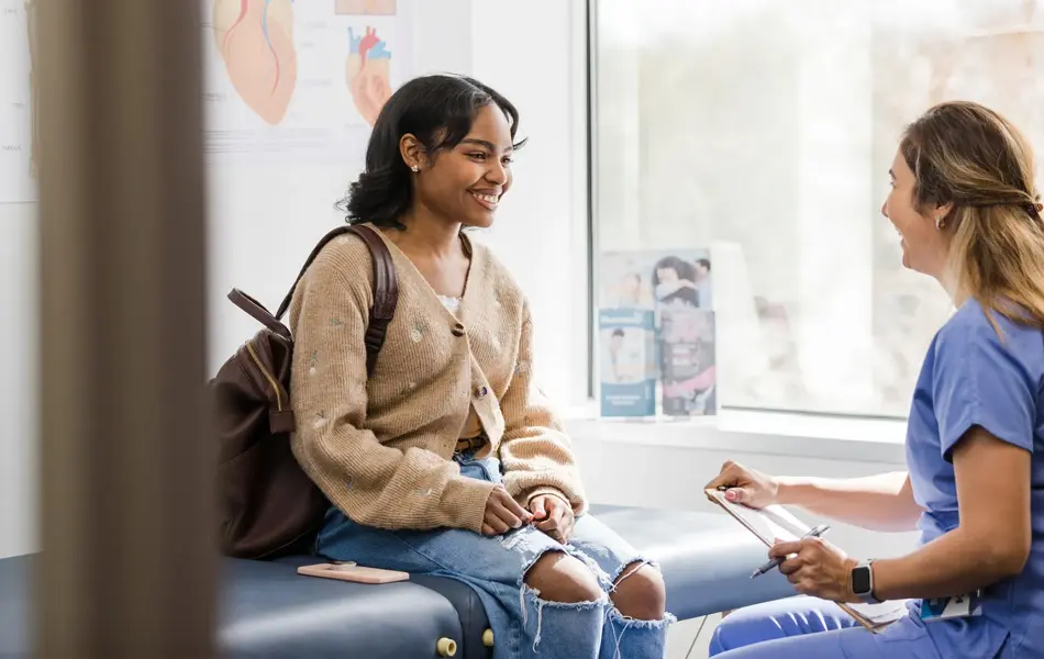 ung jente som snakker med helsesøster på kontoret hennes