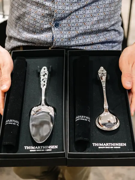 Mann som holder sølvbestikk