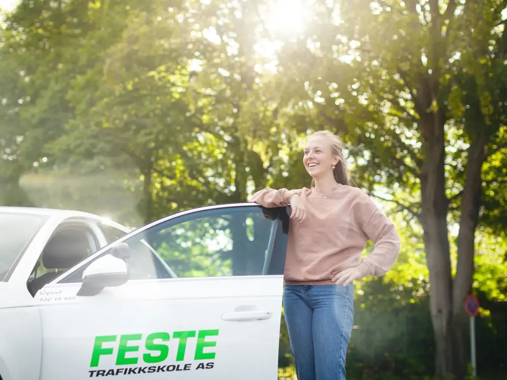 Bilde av jente på vei inn i bilen som har logo for Feste trafikkskole