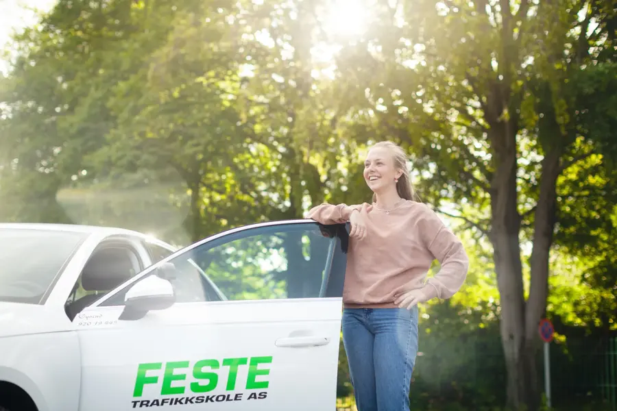 Bilde av jente på vei inn i bilen som har logo for Feste trafikkskole