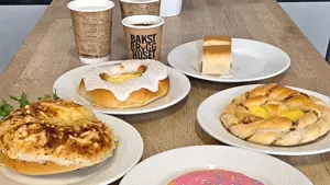 Hvite tallerkener med bakevarer og hvite og bruke kaffekopper