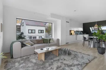 Bilde av stue med sofa, bord, stort teppe og stort vindu fra boligprosjektet Saras Hage i Tromsø