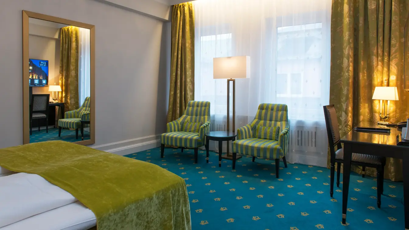 Dobbeltseng med to sitteplasser og skrivepult på Hotel Bristol i Oslo sentrum