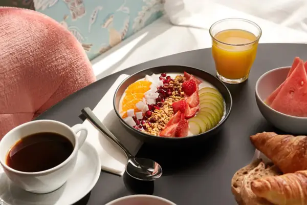 god frokost med juice, kaffe, yogurtbowl, vannmelon og croissanter