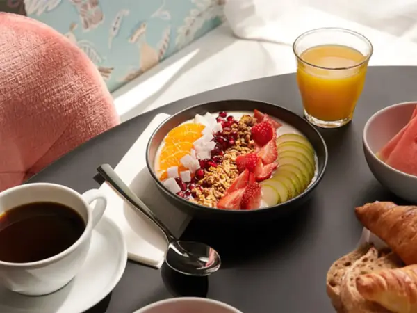 god frokost med juice, kaffe, yogurtbowl, vannmelon og croissanter
