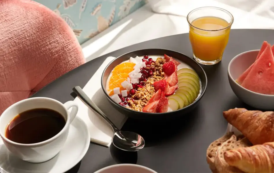 god frokost med juice, kaffe, yogurtbowl, vannmelon og croissanter