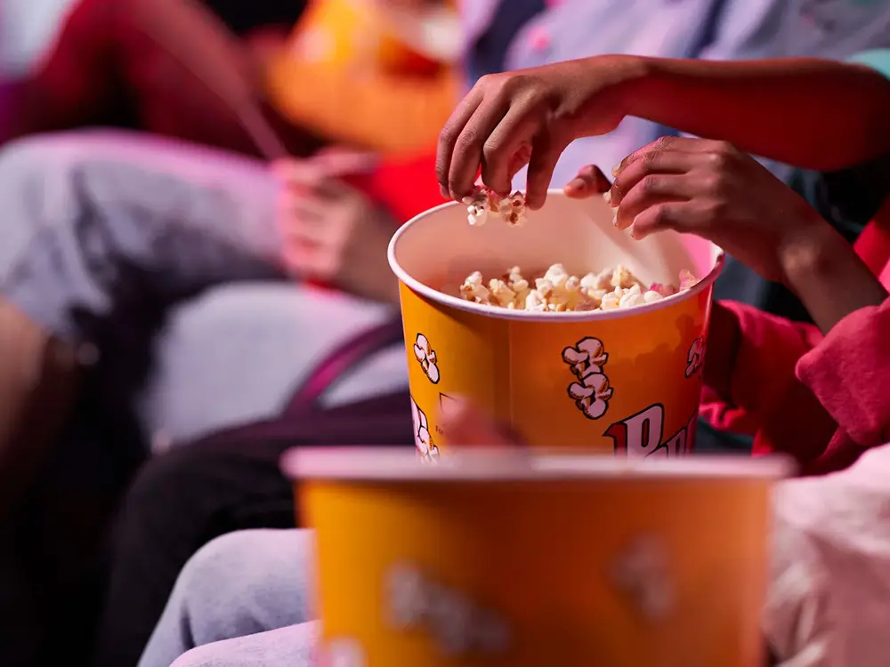 en gruppe venner som deler popkorn med hverandre på kino