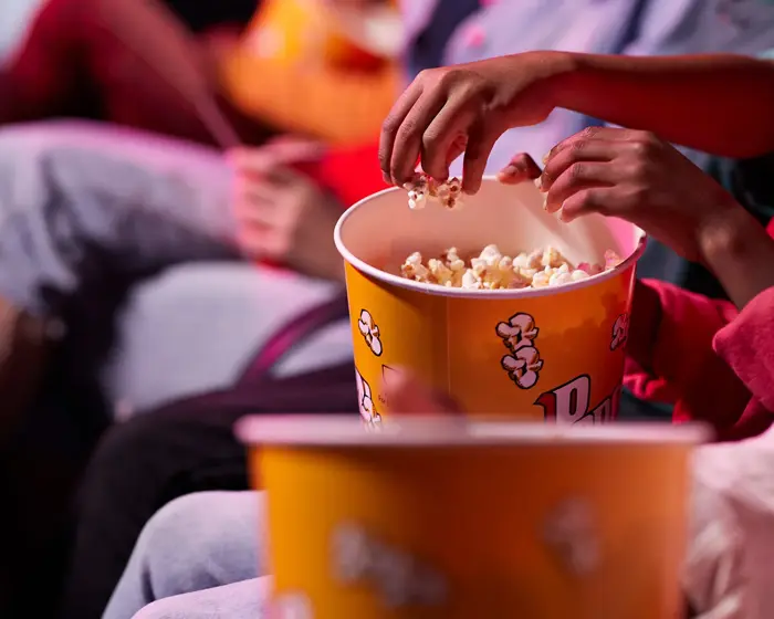 en gruppe venner som deler popkorn med hverandre på kino