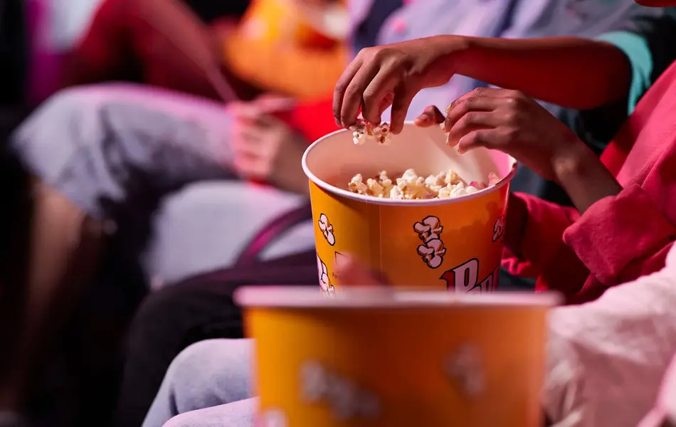 en gruppe venner som deler popkorn med hverandre på kino