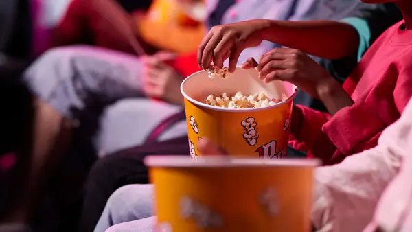 en gruppe venner som deler popkorn med hverandre på kino