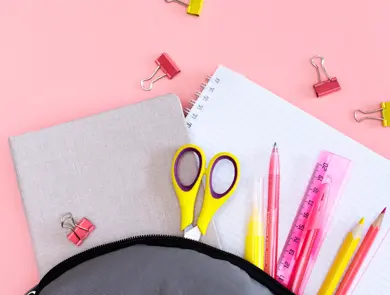 Notepad pen and glasses on a pink background, Soon to school