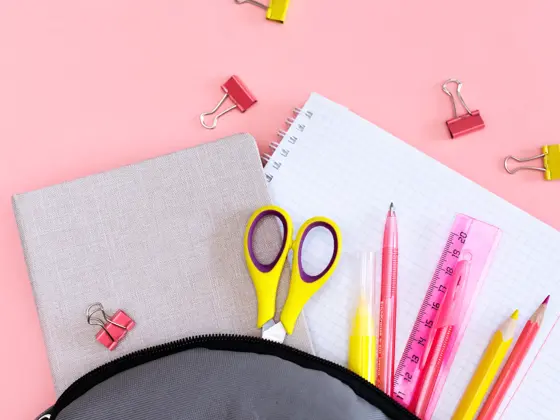 Notepad pen and glasses on a pink background, Soon to school